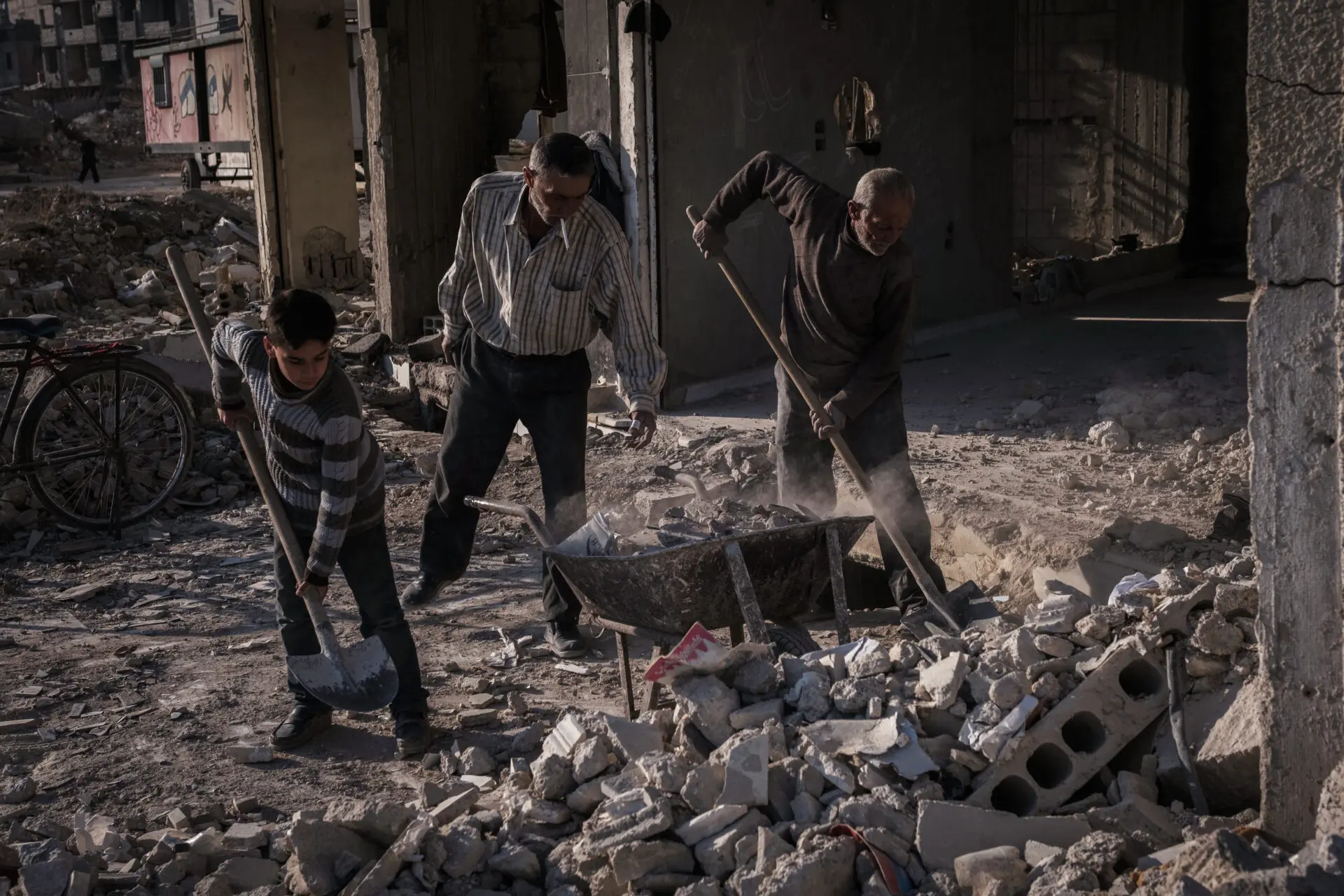 Hired workers removing rubble. Removing the rubble created by years of war will be one of the most challenging tasks of the new government --without international help, qualified civil engineers, and heavy machinery, this task will likely take decades before neighborhoods resemble some normalcy.