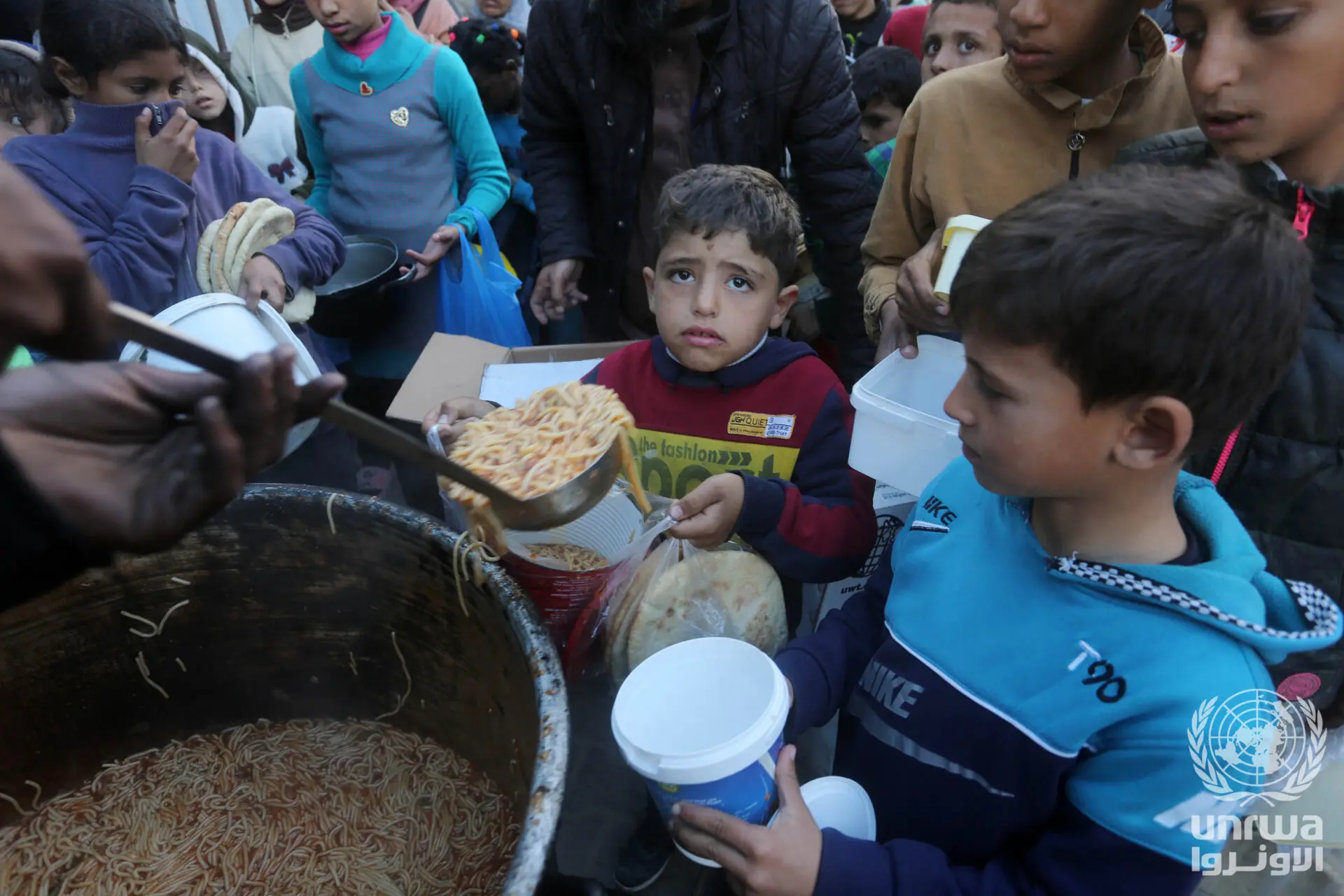 Displaced_Palestinians_receive_food_from_charitable_Tekiya_during_Ramadan_in_Deir_el-Balah,_Gaza_Strip