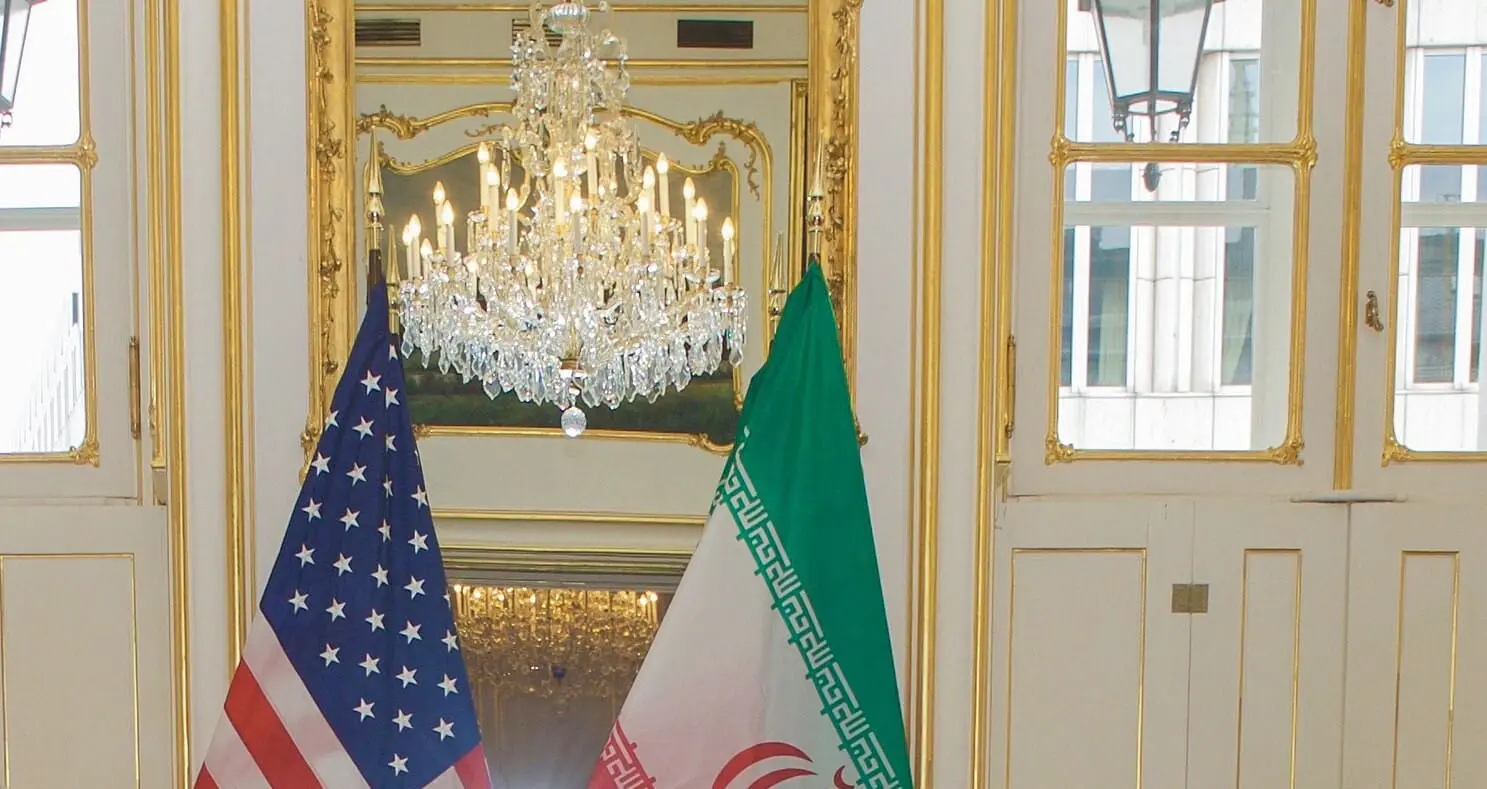 crop from U.S. Secretary of State John Kerry takes his seat across from Iranian Foreign Minister Javad Zarif on January 16, 2016, at the Palais Coburg Hotel in Vienna, Austria, before a meeting about the implementation of the Joint Comprehensive Plan of Action outlining the shape of Iran's nuclear program. [State Department Photo/Public Domain]